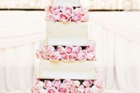 a romantic square wedding cake with pink roses between the tiers and white ribbons is chic and very inspiring