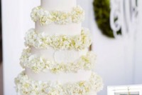 an elegant white patterned wedding cake with neutral hydrangeas between the tiers is a chic option