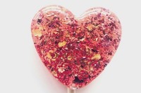 a pink heart-shaped lollipop with gold foil and dried blooms inside is a great idea for a glam wedding or for a Valentine’s Day celebration