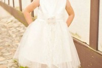 a white sleeveless dress with a plain top and a layered tulle skirt, cowboy boots and a cool braided updo