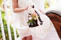 a white sleeveless lace midi dress with thick straps, pleating and a strand of pearls plus cowboy boots