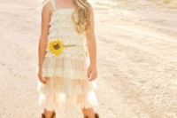 a white lace ruffle knee dress with thick straps, cowboy boots and a small sunflower to highlight the look of the girl
