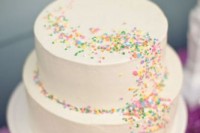 a simple white wedding cake with colorful sprinkle patterns all over it is a fun and cool idea to rock