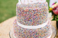 a two-tier sprinkle wedding cake with white chocolate ribbons and edible monogram for a funny and creative wedding cake