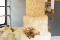 a refined white and gold sprinkle wedding cake with gold sugar blooms and matching mini cakes for a sophisticated wedding