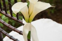 a white calla lily arrangement attached to the chair is a beautiful idea to accent your wedding aisle and isn’t difficult to make