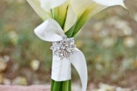 a white calla lily wedding bouquet with a ribbon wrap and a vintage brooch is a chic and stylish idea for a bride