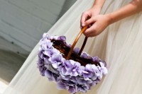 a flower girl basket decorated with purple blooms is a beautiful option