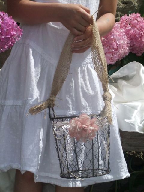 a wire bucket with a burlap handle and a pink fabric bloom for decor