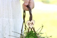 a vine basket with moss, succulents and a heart with monograms for a rustic wedding