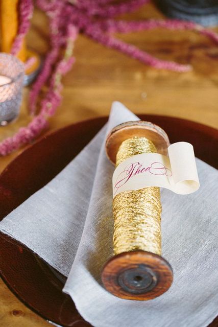 gold yarn and ribbons with a ribbon with the guest's name is a veyr creative idea of a place card