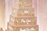 a very tall blush square wedding cake with traditional cartoon decor and a castle topper