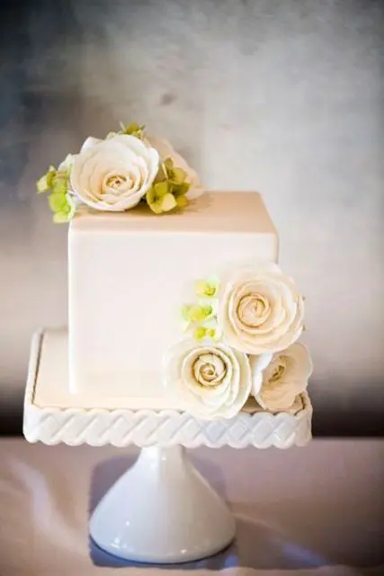 a small squre wedding cake in white decorated with fresh blooms is a timeless idea to rock