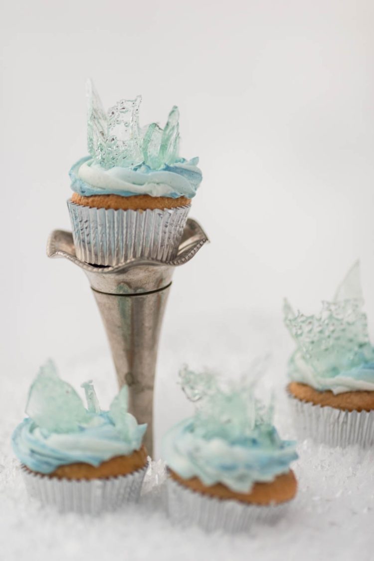 Frozen-themed wedding cupcakes with blue icing and clear blue shards on top look fantastic