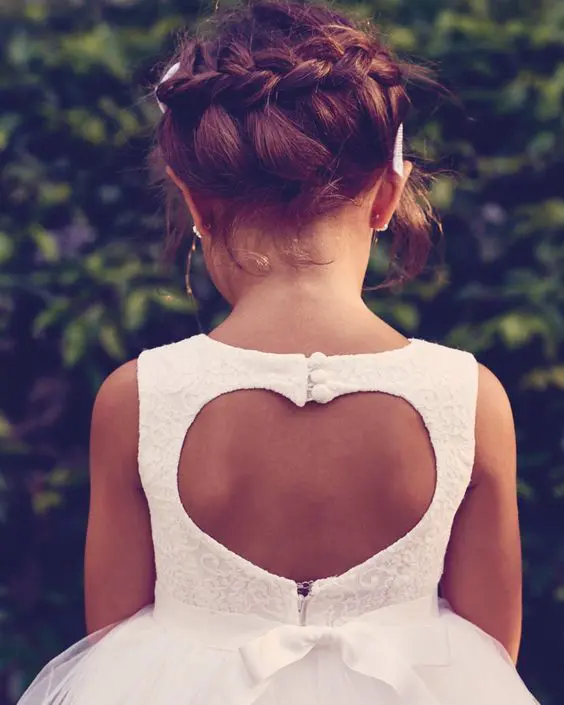a boho braided updo with locks down and a messy feel is a pretty solution for many flower girl styles