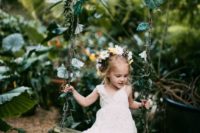 a boho lace A-line flower girl dress with no sleeves and a V-neckline plus flat sandals
