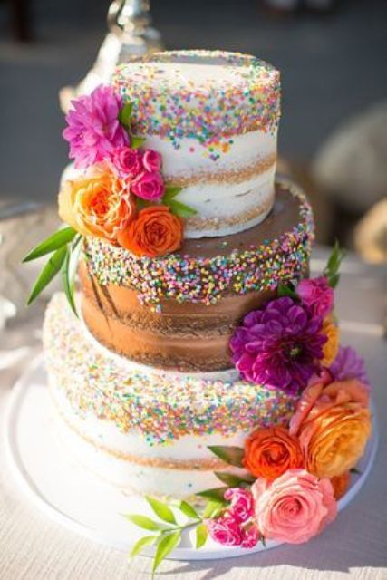 a bold wedding cake with naked vanilla and chocolate tiers, with sprinkles and bold blooms and greenery