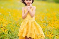 a bright yellow high low maxi dress with spaghetti straps and a ruffle skirt, cowboy boots and a floral crown for a bright rustic wedding