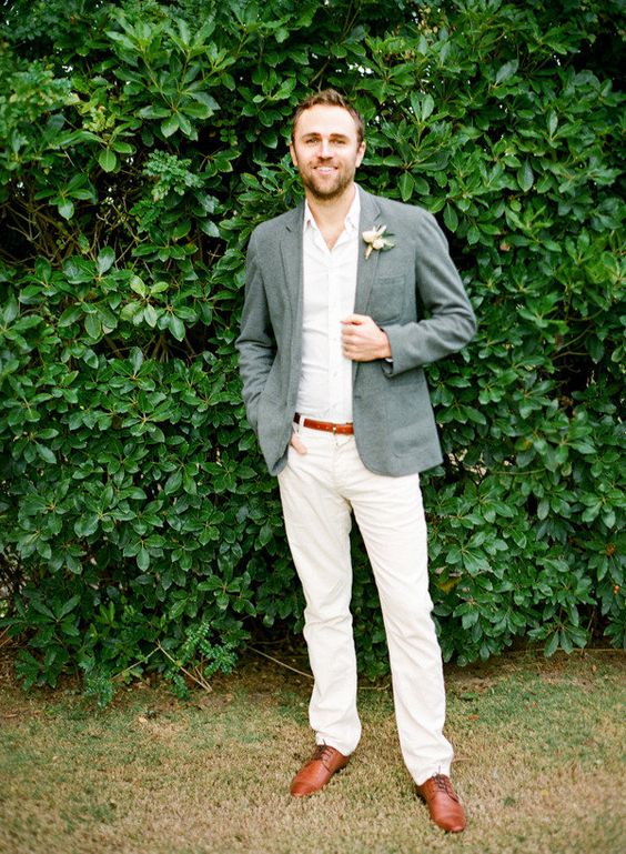 a chic and simple outfit with white pants and a shirt, a grey jacket, brown shoes and a florla boutonniere
