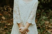 a chic white lace A-line dress with bell sleeves, a high neckline and a greenery crown for a cozy look