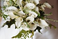 a classic and lush wedding bouquet of white calla lilies, greenery and twigs is a stylish solution for a timeless bridal look