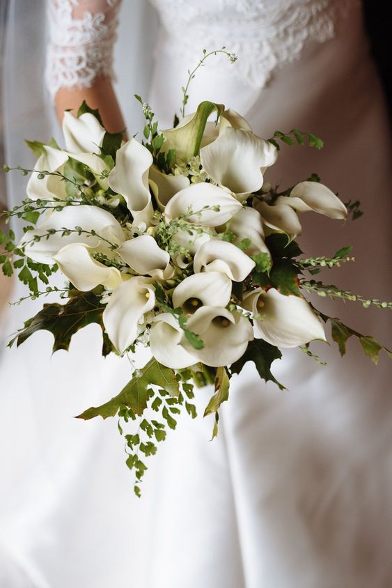 a classic and lush wedding bouquet of white calla lilies, greenery and twigs is a stylish solution for a timeless bridal look