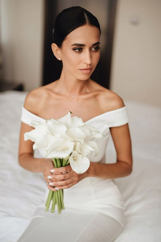 a classic white calla wedding bouquet perfectly matches the refined minimalist bridal look here