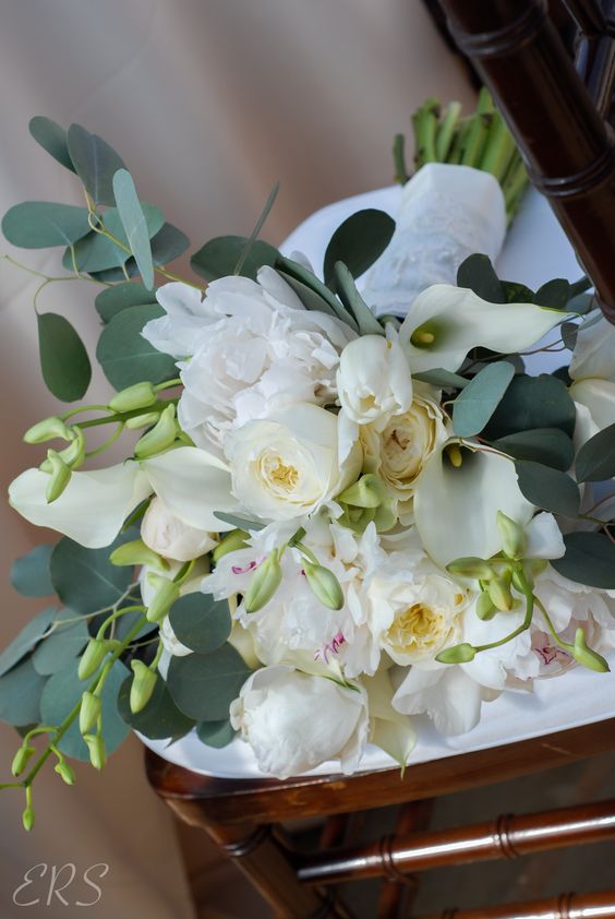 a delicate wedding bouquet of white callas, peonies and peony roses and some greenery is a lovely idea for spring or summer