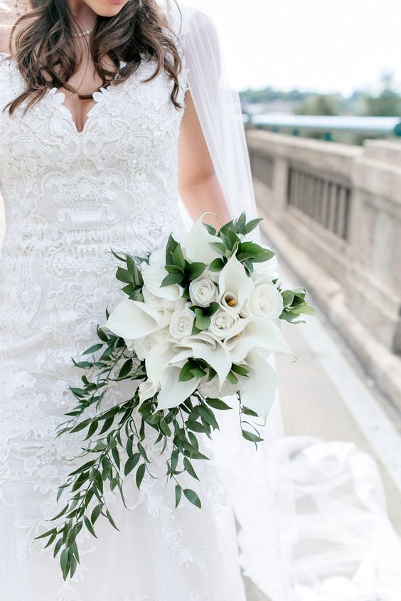 a fab wedding bouquet of white roses and calla lilies plus some greenery is a stylish idea for a spring or summer wedding