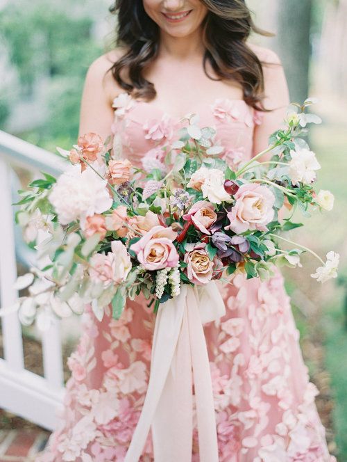 a fabulous dimensional wedding bouquet of rose quartz blooms, dark foliage and greenery plus long ribbons is a beautiful idea
