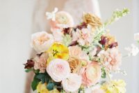 a fantastic fine art wedding bouquet of rose quartz, yellow and peachy blooms, greenery and dark foliage is a refined solution for a summer or fall wedding