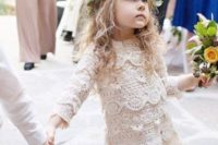 a gorgeous boho lace flower girl dress with long sleeves, an over the knee skirt and a high neckline