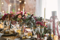 a lush and moody Sleeping Beauty wedding tablescape with moody florals, pale greenery, candles, gold rimmed glasses