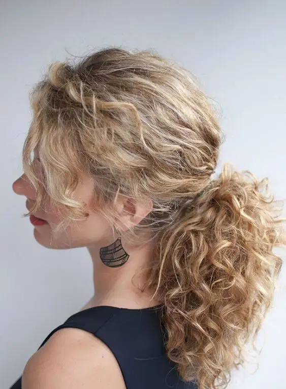 a messy low ponytail with bangs is a chic idea to rock for a modern wedding, it will take you a minute to make