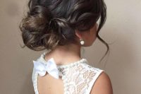 a messy low updo with waves, a volume on top and some locks down is a very chic and cool idea