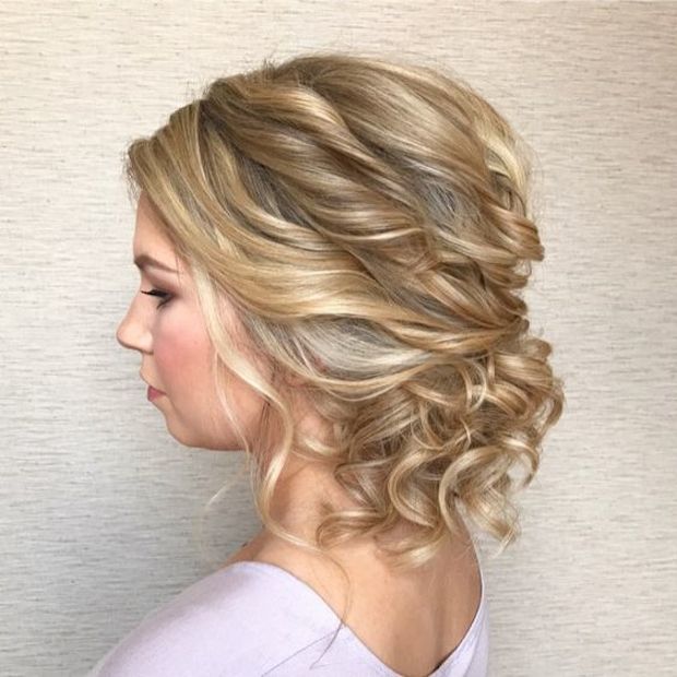 a messy twisted low updo with curls and bangs is a very romantic option, which fits many bridal styles