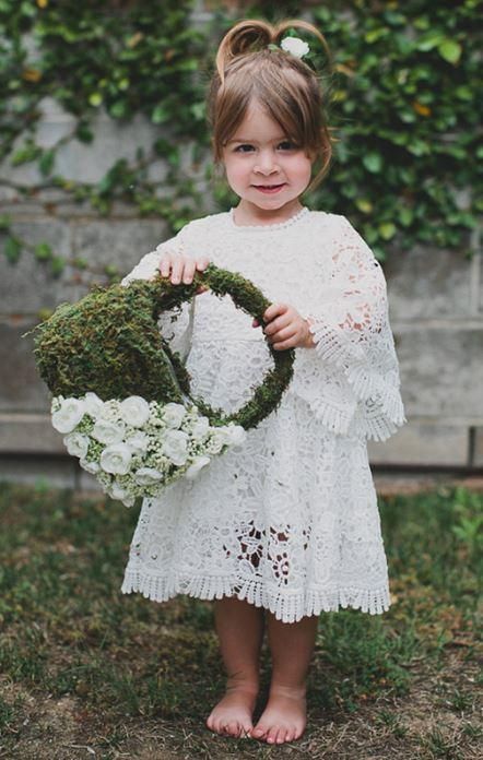 a moss flower girl basket with white berries and blooms is a stylish idea with a boho feel