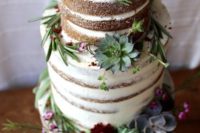 a naked wedding cake with succulents of various shades and burgundy blooms, with herbs for a bold look