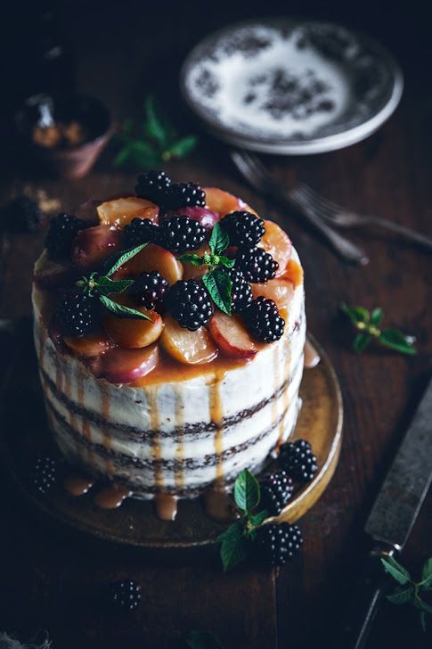 a peach naked wedding cake with cream cheese frosting, blackberries, peaches and peach drip for a summer wedding