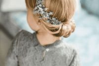 a pretty twisted low updo with a pale greenery crown is a beautiful idea for medium length hair