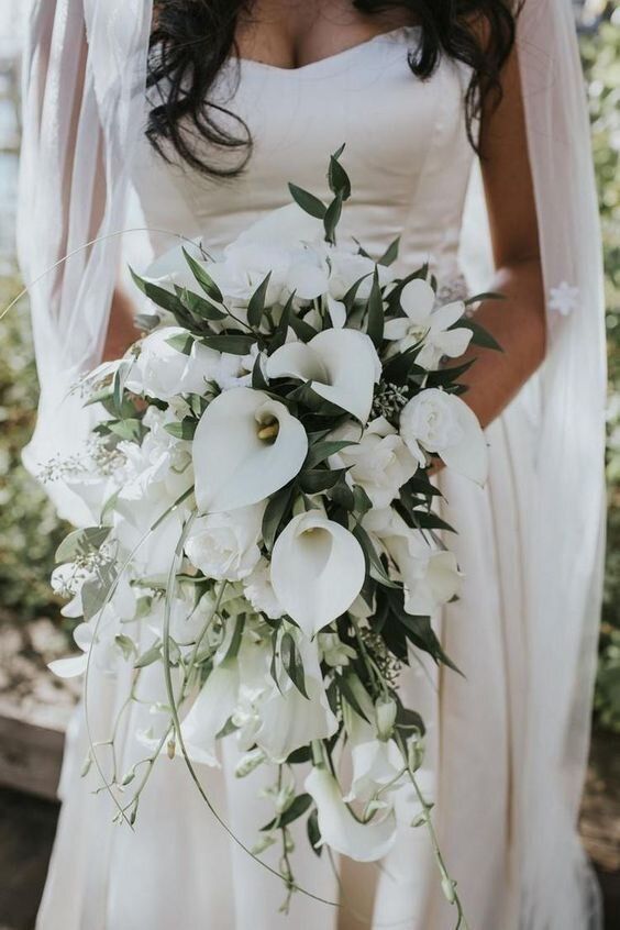 a refined white wedding bouquet with calla lilies and greenery is a chic and sophisticated wedding idea to rock