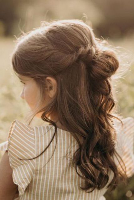 a relaxed flower girl hairstyle with a bump, with a bun and waves down is a chic and lovely idea for a more relaxed flower girl look