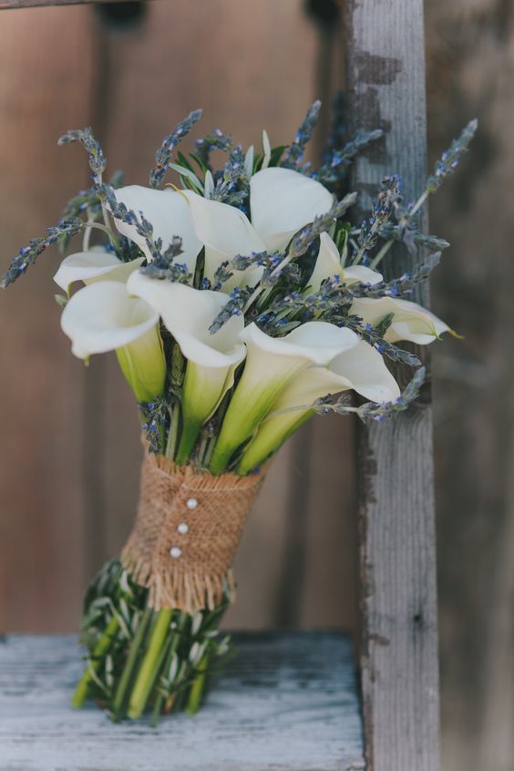 a rustic wedding bouquet of white callas, lavender and a burlap wrap with buttons is a lovely and out of the box idea