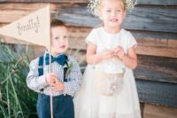 a simple white knee dress with short sleeves, a high neckline, cowboy boots and a baby’s breath crown
