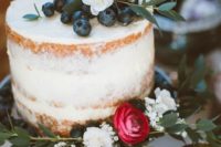 a small naked wedding cake topped with blueberry and flowers plus some greenery is awesome for a spring or summer wedding