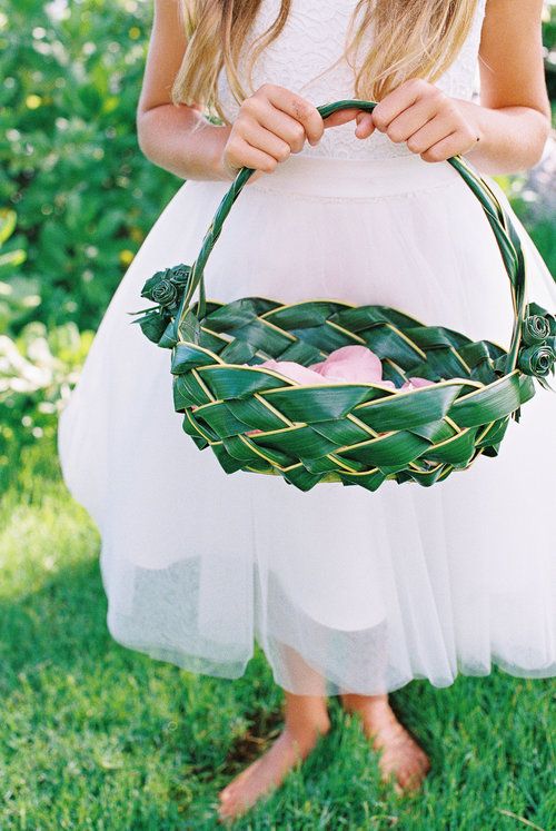a unique flower girl basket made of a tropical leaf interwoven and decorated with blooms made of it, too