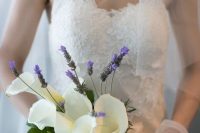 a unique wedding bouquet of white callas, some bold blooms and greenery plus a white ribbon bow