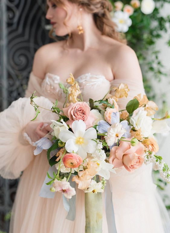 a very sophisticated spring pastel wedding bouquet with white, rose quartz and light blue blooms and some foliage is awesome