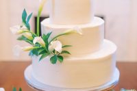 a white buttercream wedding cake decorated with foliage and white callas is a lovely idea for a fall or summer wedding