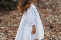 a white cotton A-line knee dress with short sleeves and a lace skirt plus sandals and a baby’s breath crown